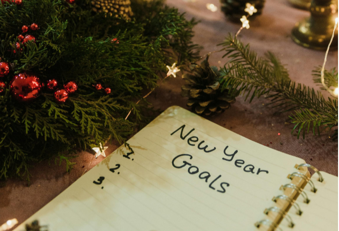 Libreta en la que escribir los propósitos de Año Nuevo rodeada de adornos navideños (Foto: Pexels)